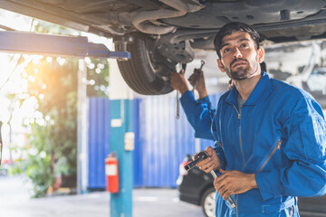 Auto check up and car service shop concept. Mechanic writing job checklist to clipboard to estimate repair quotation to client at workshop garage.