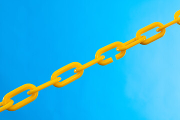 Yellow plastic chain on blue background