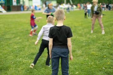 Naklejka premium Child on green grass. Schoolboy plays on lawn in summer. Active holidays.