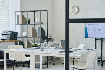 Horizontal image of modern board room with table for meeting and screen for presentation