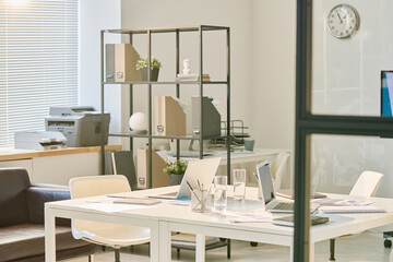 Horizontal image of table with laptops and documents standing in the middle of board room