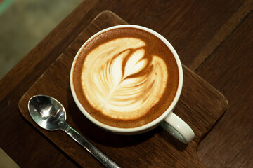 White cup of tasty cappuccino with art latte.