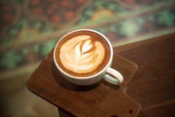 White cup of tasty cappuccino with art latte.