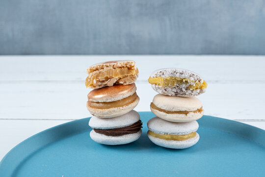 Closeup of a stack of macarons filled with chocolate ganache, dulce de leche and passion fruit cream.