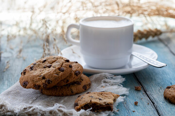 Chocolate chip cookies and a cup of latte on a blue wooden table