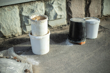 Buckets of sand against wall. Building material for repair.