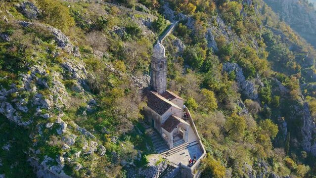 Aerial shot of the Christian church on a way to the top of the mountain where st. John's fort is located. Crkva Gospe od Zdravlja, church of St. Mary of Health in Kotor. Travel to Montenegro concept