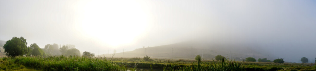 Naklejka na ściany i meble Camping in the nature waking up into a misty sunrise