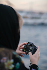 Fototapeta premium woman taking photos of a river with a digital camera
