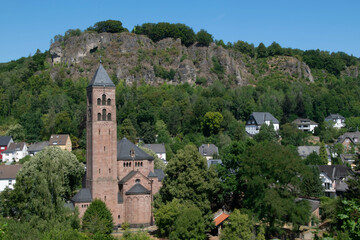 Fototapeta na wymiar Church in the village of Gerolstein in the German Eifel with the rocks of the Gerolsteiner Dolomites in the background and the view point Munterley