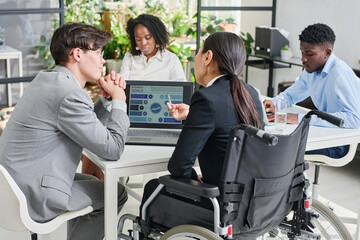 Rear view of business colleagues looking at monitor of laptop while developing new strategy...