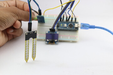 Digital soil moisture meter project made at home using micro controller and some other electronic components assembled on a breadboard circuit