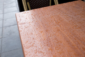 The surface of the table is covered in drops after rain.