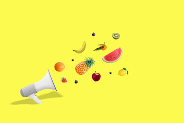 Megaphone with fresh fruit on yellow background. Healthy lifestyle concept. 