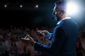 Motivational speaker with headset performing on stage - obrazy, fototapety, plakaty