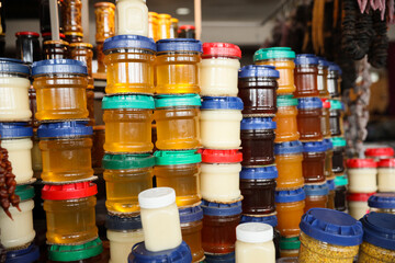 Jars with aromatic honey and different jams at market