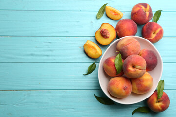 Fresh sweet peaches on turquoise wooden table, flat lay. Space for text