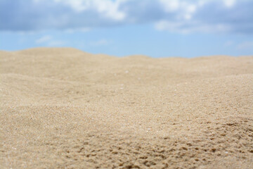 Fototapeta na wymiar Beautiful sand in desert under cloudy sky, closeup