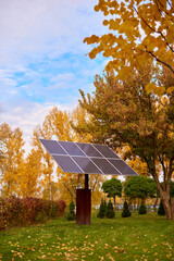 Solar panels, photovoltaic - alternative electricity source. Beautiful yellow trees in autumn....
