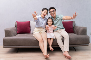 Young Asian family sitting on sofa
