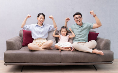 Young Asian family sitting on sofa