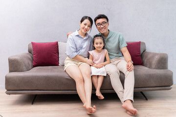 Young Asian family sitting on sofa