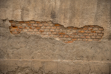 Particolare di muro vecchio con cemento rovinato e mattoni in vista