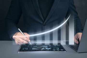 Businessman using tablet analyzing sales data and economic growth graph chart. Business strategy,...