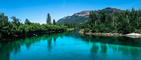 Tranquil landscape of the turquoise-colored river water and green forest at Fortune Creek park in...