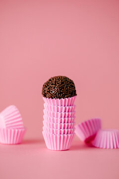 Brigadeiros de chocolate em fundo infinito rosa	
