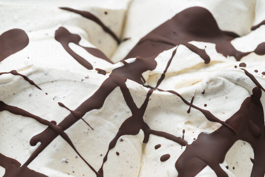 Frozen Stracciatella flavour gelato - full frame detail. Close up of a white surface texture of  Ice cream covered with brown chocolate stripes and dots.