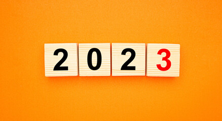 Wooden cubes with the letters 2023 on an orange background