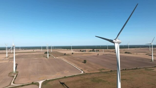 Panoramic aerial view of wind farm or wind park, with high wind turbines for generation electricity. Green energy concept.