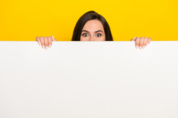 Photo portrait of lovely young woman hiding behind white wall blank space wear stylish striped...