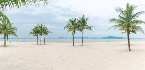Fototapeta na wymiar Panorama view beautiful wedding decorations along sandy beach with palm trees and mountains background in Ha Long Bay, Quang Ninh, Vietnam