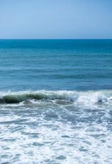 Ocean waves crashing on sandy beach. Sea waves breaking on Maditerranean's shore.
