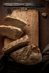 Low key food photography. Black rustic bread on dark background