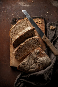 Low key food photography. Black rustic bread on dark background