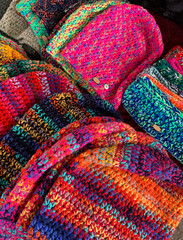 Colorful background, wool, handcarfts, glovew and caps in street market. Winter season