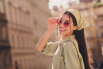Profile photo of adorable positive lady hand touch glasses beaming smile enjoy excursion city center outside