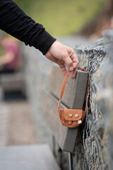 Someone lost a bag. A man 's hand takes a found lost thing - a small children 's women 's handbag . Abandoned or abandoned items, lost and found