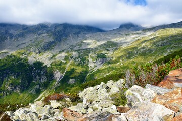 Mountain slopes bellow Hochalmspitze in High Tauern mountains with the peak covered in clouds in...