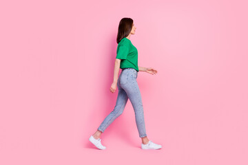 Full body photo of lovely young girl walking shopping mall weekend promo dressed trendy green clothes isolated on pink color background