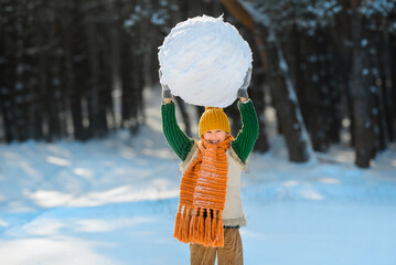 Happy smiling boy playing with a huge snow globe. Winter entertainment for children. A child...