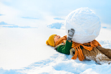 Happy little child boy lying in snow with big snow globe. Happy winter holidays concept. Place for...