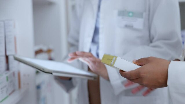 Pharmacists scrolling, browsing and planning on digital tablet while counting, sorting and ordering new stock in drugstore. Closeup of organised healthcare staff checking inventory of medicine online