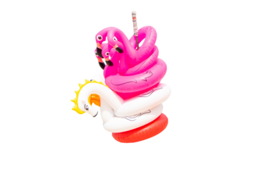 Close up multicolor flamingo shape fancy floating. Suitable for travel. Summer time concept. Stack together on the beach by the sea in the bright sunlight.