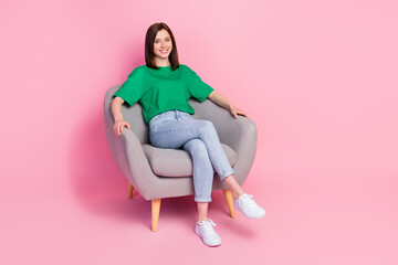 Full size portrait of gorgeous satisfied girl sitting comfy chair toothy smile isolated on pink color background