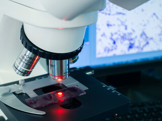 The working area of the microscope with different magnifying objectives and a glass slide with...