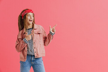 White woman with dreadlocks smiling while pointing finger aside